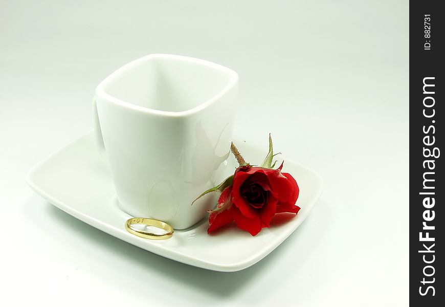 White cup whit red rose and ring