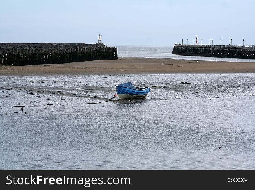 Tide will come in between the piers and the coble fishing boatwhich is now resting on the floor will float again