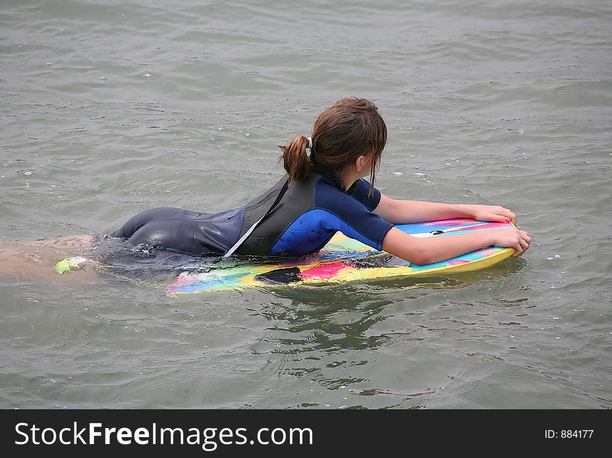 A girl waiting on her boogie board for the next wave. A girl waiting on her boogie board for the next wave