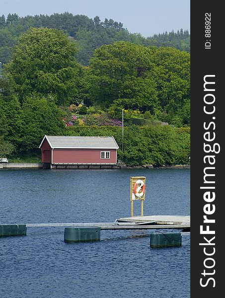 Floating boathouse and lifesaving ring on a floating quay at Farsund on the south coast of Norway