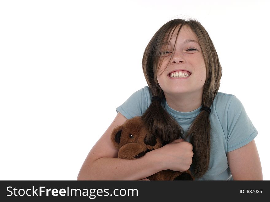 Little girl with big, cheshire cat grin, smiling and sitting on floor holding a teddy bear.  Shot on white. Little girl with big, cheshire cat grin, smiling and sitting on floor holding a teddy bear.  Shot on white.