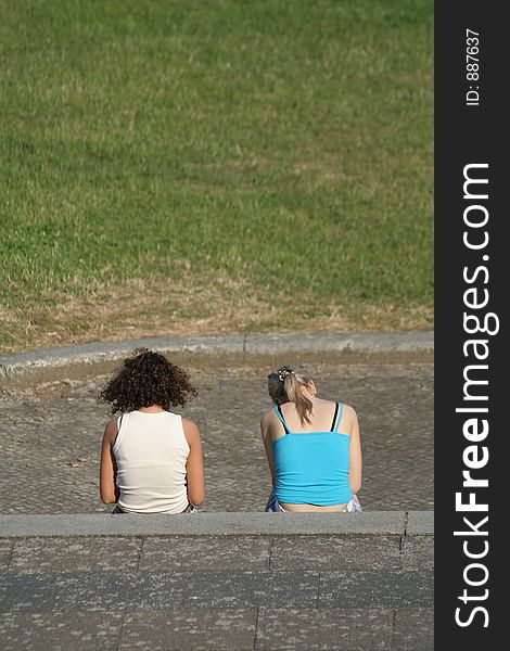 Two girls siting and reading textbook