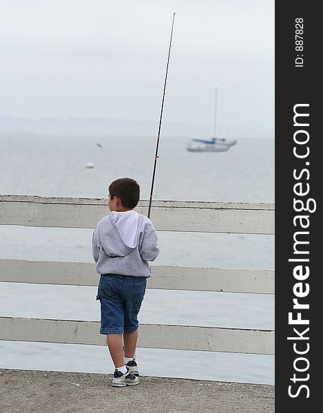 A boy fishing from the pier