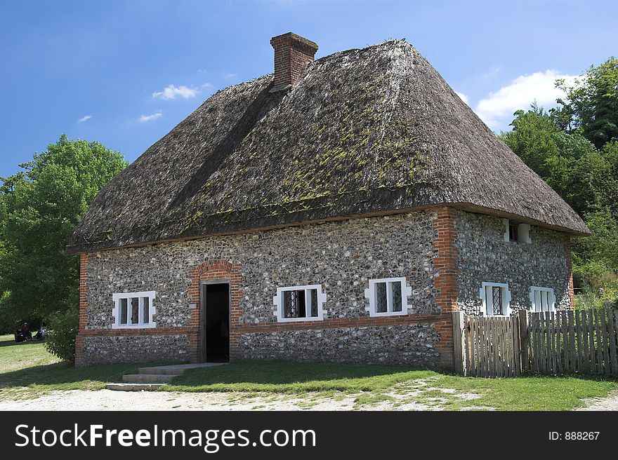 Rurall cottage with thatched roof and flint walls. Rurall cottage with thatched roof and flint walls