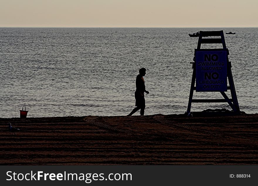 Sihlouette of lonely man and lifeguard tower on beach