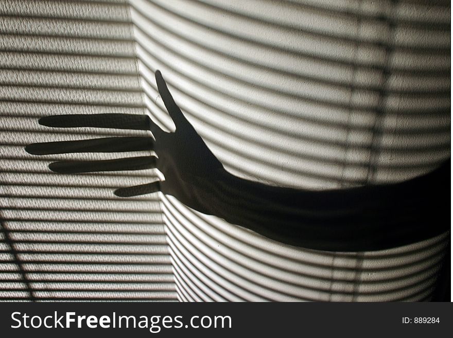 Shade of a hand with striped wall in the background