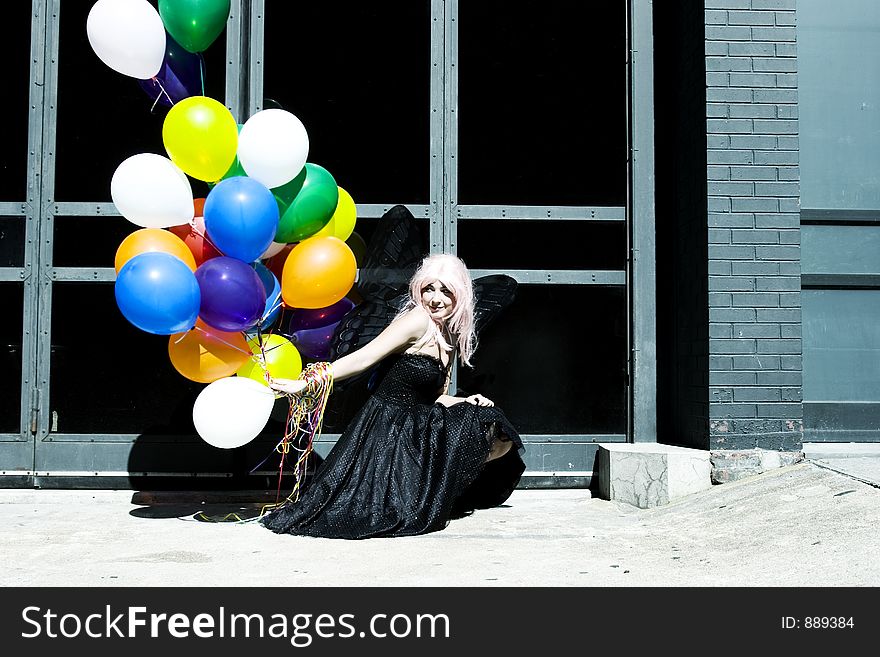 Pink haired fairy with balloons out in the sun