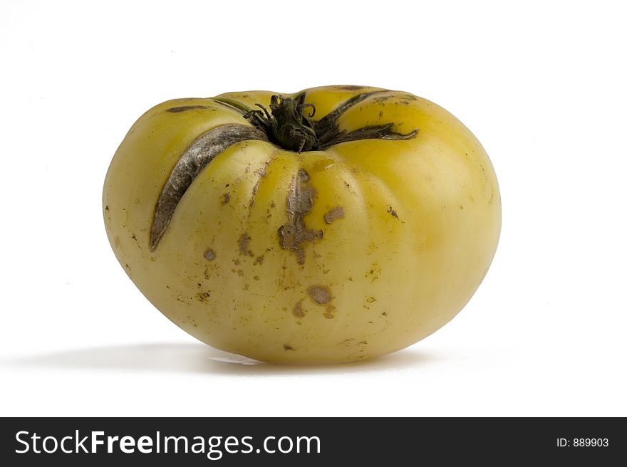 A yellow heirloom tomato on a white background. A yellow heirloom tomato on a white background
