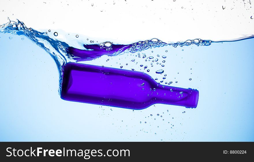 Bottle and creative splashing water.

Isolated on white