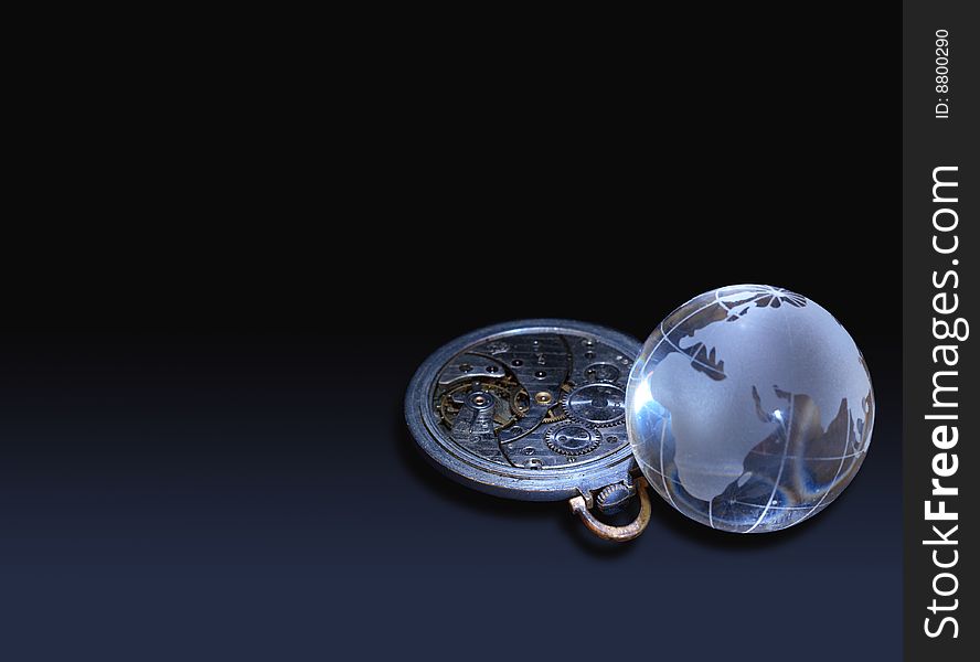 Glassy globe with old watch mechanism lying on dark background. Glassy globe with old watch mechanism lying on dark background