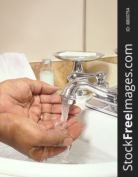 Washing hands in sink under running water