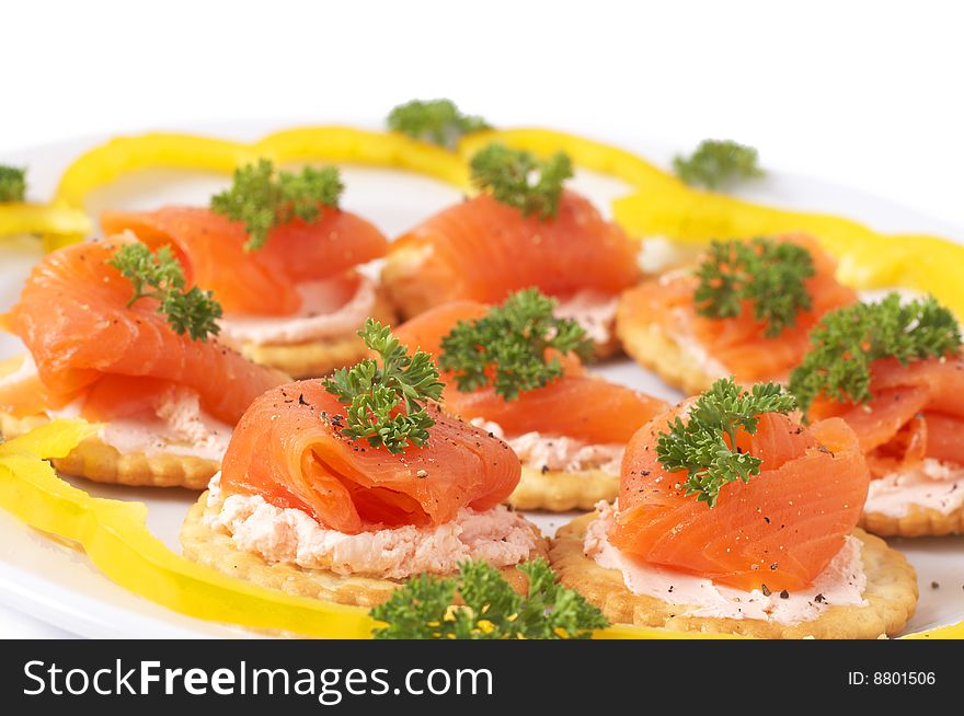 Smoked salmon and cream cheese on mini crackers with freshly cracked black pepper and garnishing of parsley. Smoked salmon and cream cheese on mini crackers with freshly cracked black pepper and garnishing of parsley