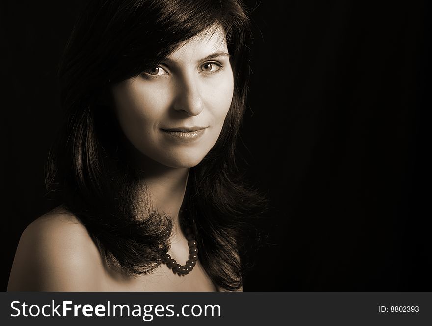 Portrait of young woman on black background