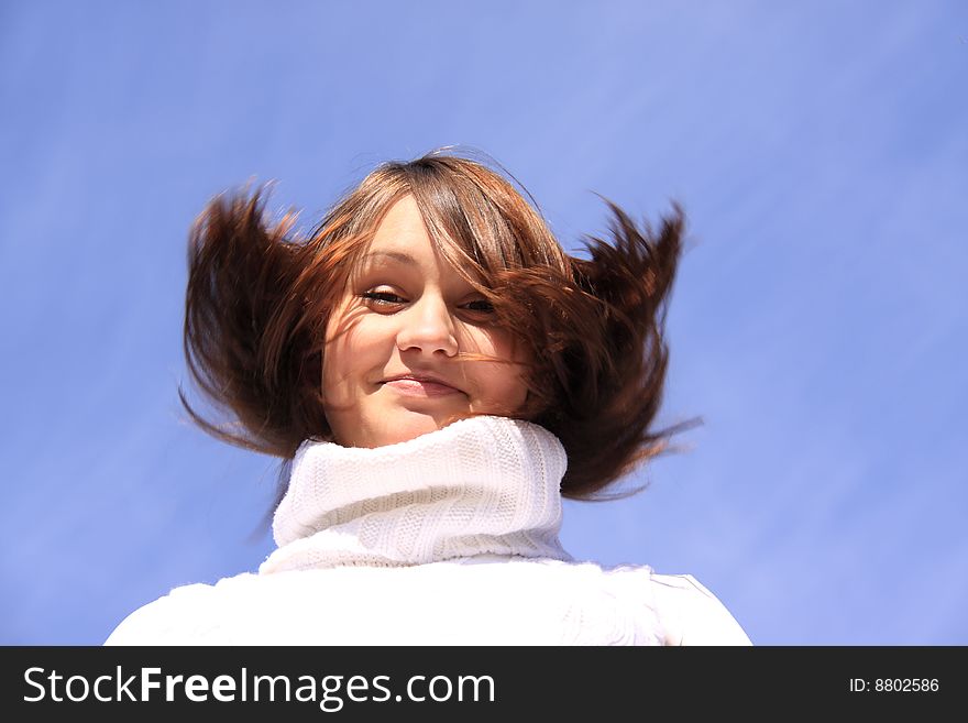 Girl in a white sweater with a collar on a background blue sky