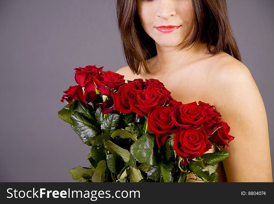 A nude beautiful woman covering her breasts with roses. A nude beautiful woman covering her breasts with roses
