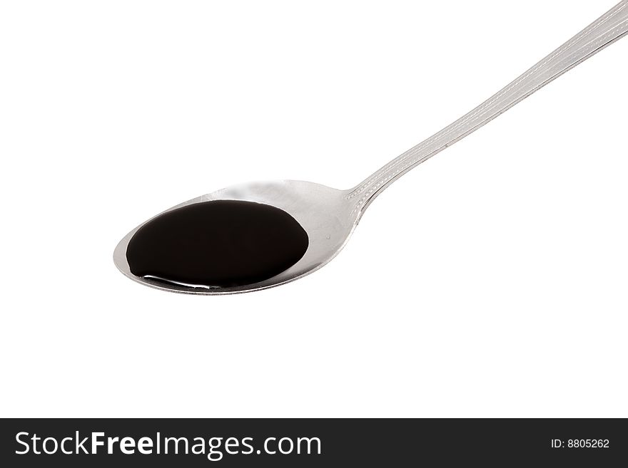A spoon full of some brown liquid medicine - cod liver oil. A spoon full of some brown liquid medicine - cod liver oil