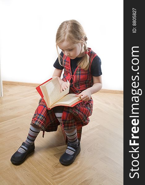 Serious schoolgirl with red book over white. Serious schoolgirl with red book over white