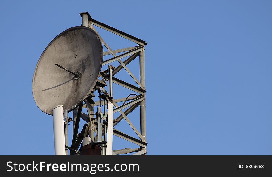 A antenna in front of a blue sky.