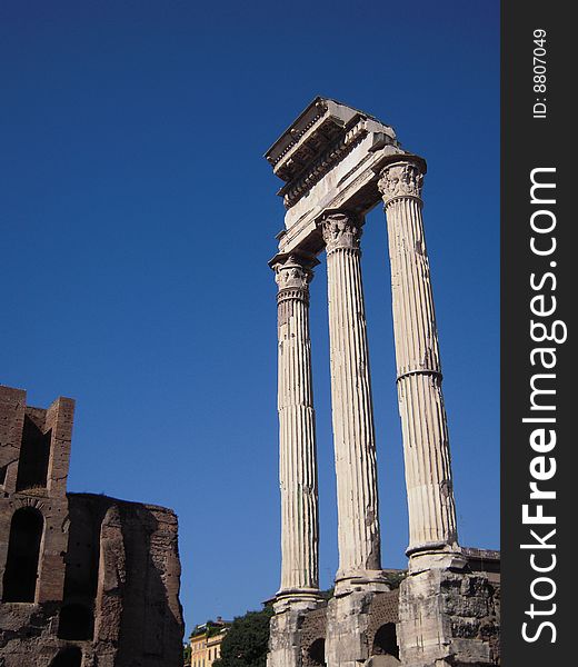 The corinthian column triad in Ancient Rome.  In the background, the sky was a deep blue. The corinthian column triad in Ancient Rome.  In the background, the sky was a deep blue.