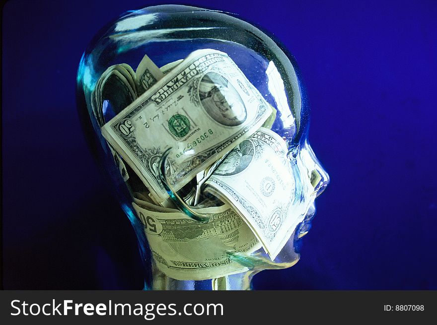 Fifty Dollar Bills in Piles inside of a glass head with a blue back round. Fifty Dollar Bills in Piles inside of a glass head with a blue back round