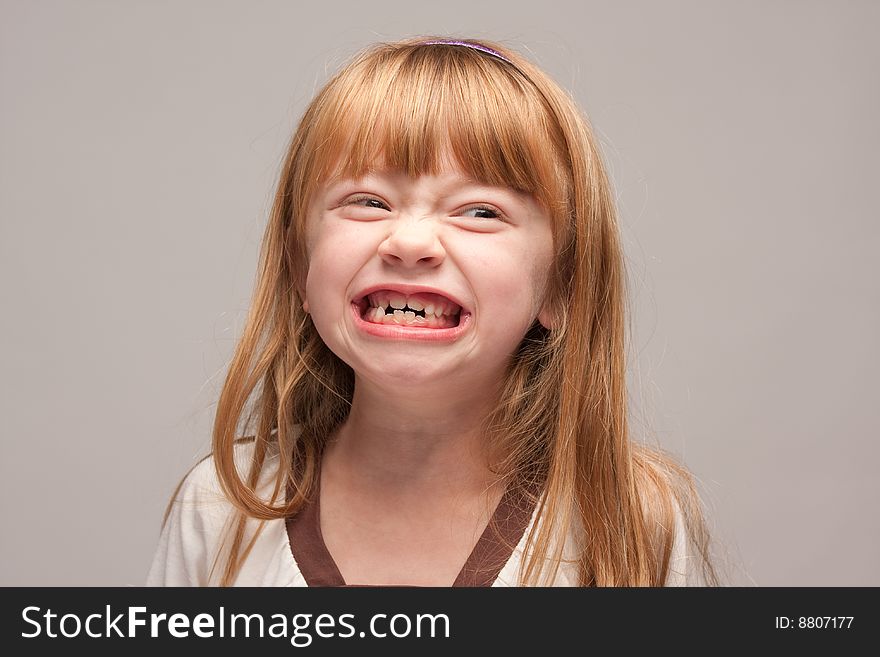 Portrait of an Adorable Red Haired Girl on a Grey Background.