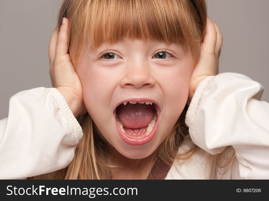 Portrait of an Adorable Red Haired Girl on a Grey Background.