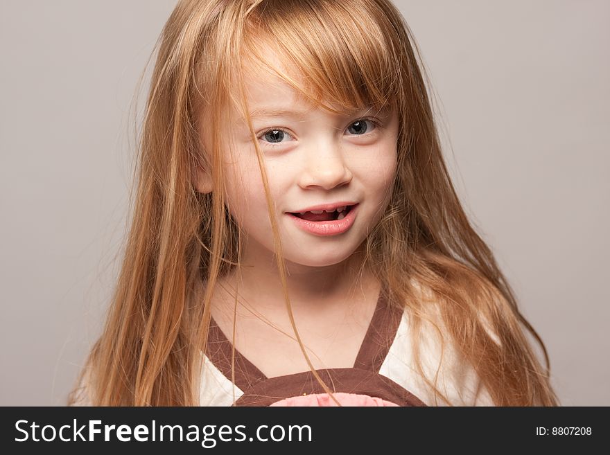 Portrait of an Adorable Red Haired Girl on a Grey Background.