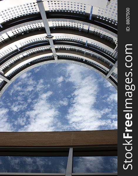 An outdoor patio with no roof, perfectly framing a partially cloudy sky. An outdoor patio with no roof, perfectly framing a partially cloudy sky