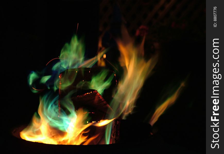 Colourful flames dancing, swirling in a bed of coals. Colourful flames dancing, swirling in a bed of coals.