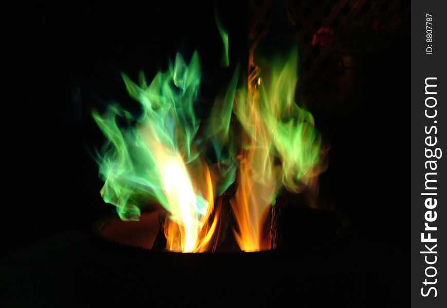 Colourful flames dancing, swirling in a bed of coals. Colourful flames dancing, swirling in a bed of coals.