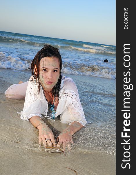 Portrait of young fashion woman lying on the sand of tropical beach. Portrait of young fashion woman lying on the sand of tropical beach