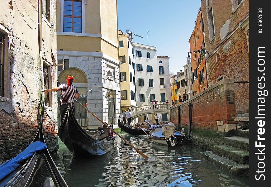 The gondoliers floats on the channel of Venice with tourists. The gondoliers floats on the channel of Venice with tourists