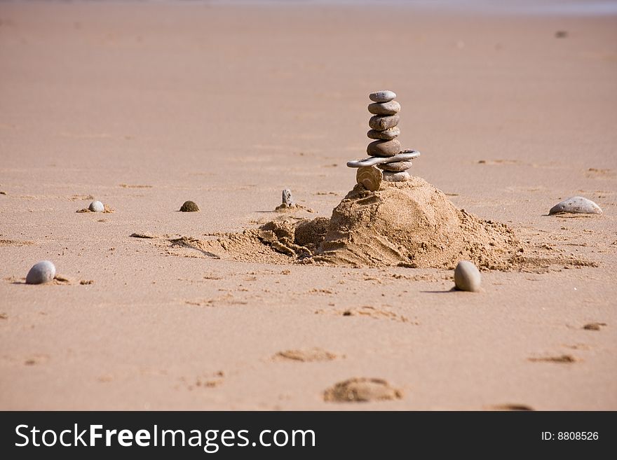 Piled up pebbles on a sandy beach. Piled up pebbles on a sandy beach