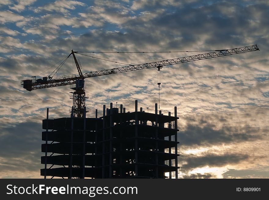 The elevating crane on ripped clouds background