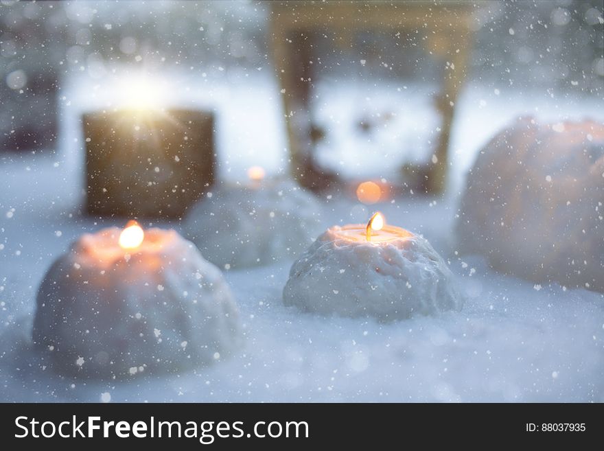 Snow lanterns with lit candles in the winter.