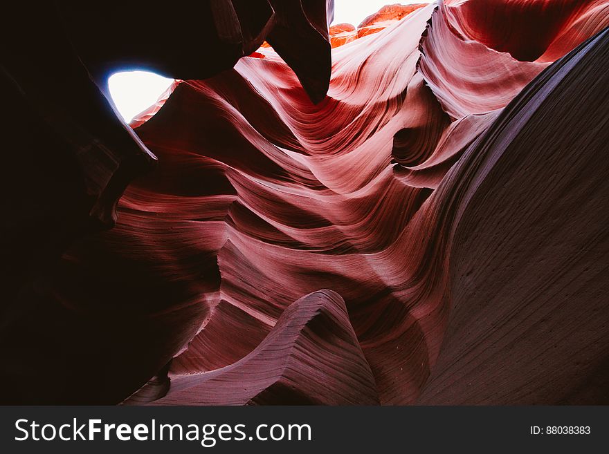 Abstract textured red, white and black background created by light falling unevenly on rocks in a canyon. Abstract textured red, white and black background created by light falling unevenly on rocks in a canyon.