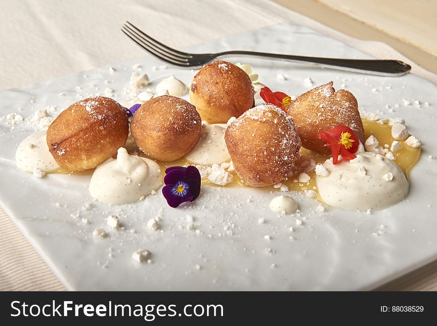A close up of sweet dough balls on a plate.