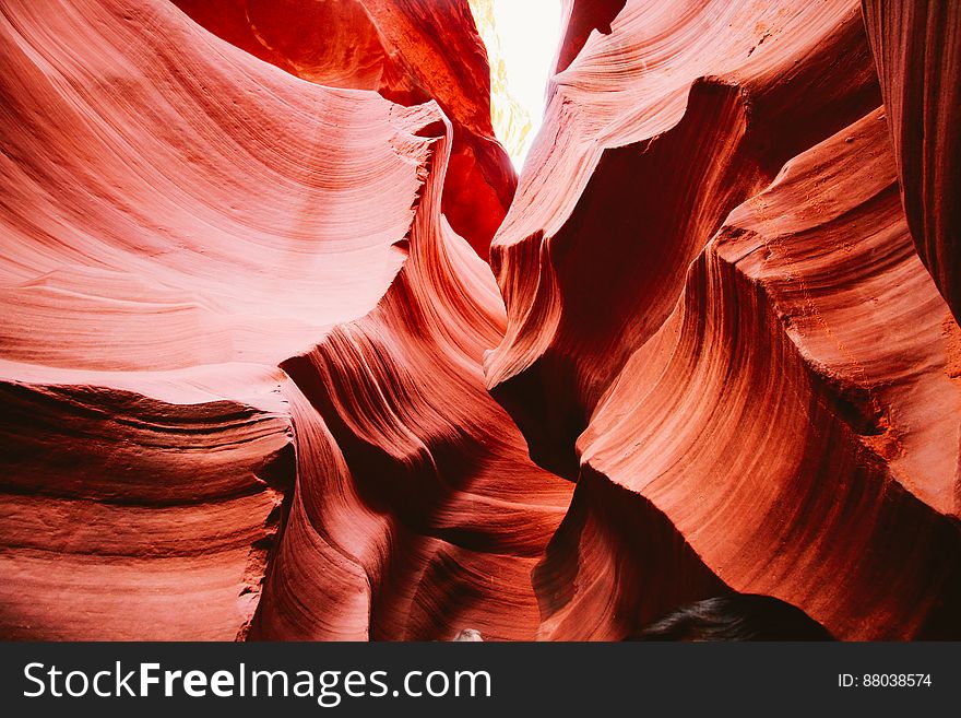 Abstract textured background created by red rocks in ancient canyon illuminated by bright sunlight. Abstract textured background created by red rocks in ancient canyon illuminated by bright sunlight.