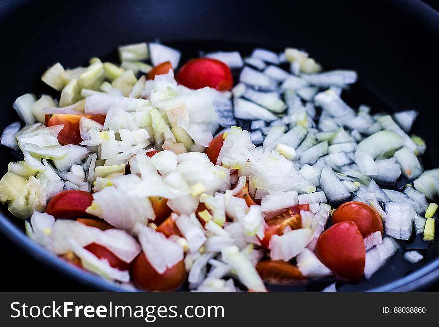 A frying pan with chopped tomatoes and onions. A frying pan with chopped tomatoes and onions.