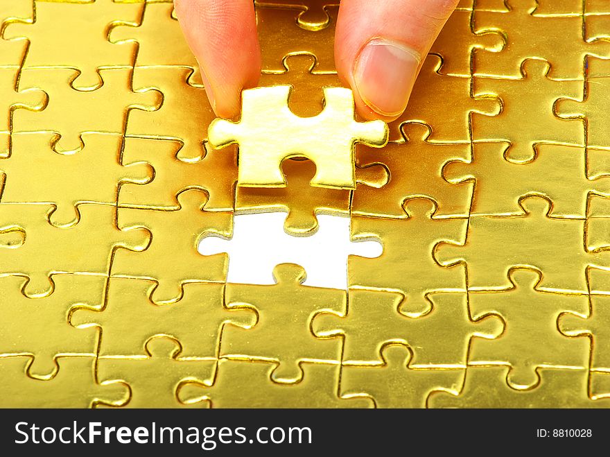 Woman fingers holdings gold puzzle