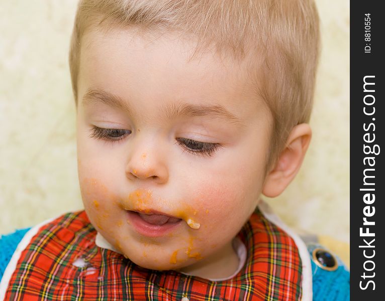 Close-up shot of cute little boy stained with squash