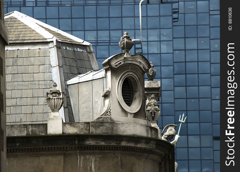 Window of an old building, classical architecture, in contrast with modern glass wall. London. Window of an old building, classical architecture, in contrast with modern glass wall. London.