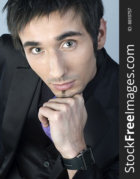 Handsome young man portrait in black suit  in studio