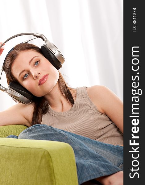 Sitting beautiful teenage girl listening to music. Sitting beautiful teenage girl listening to music