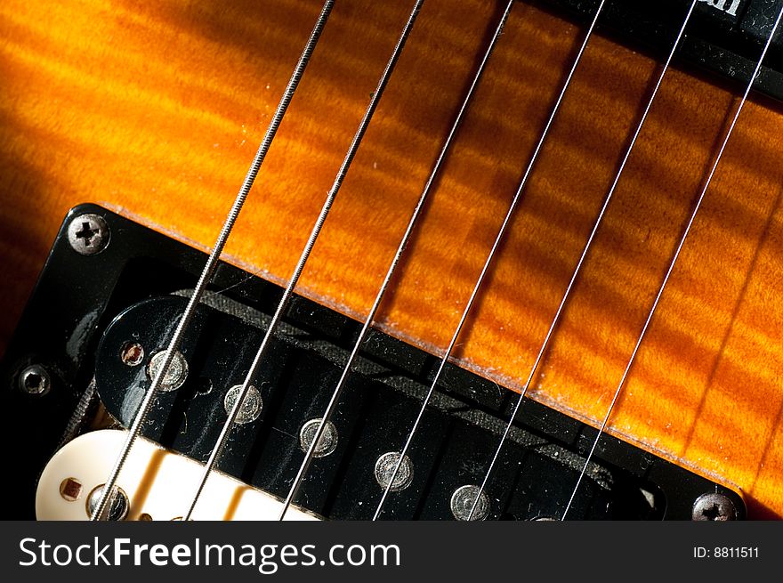 Macro shot of guitar strings, pickups and sunburst finish