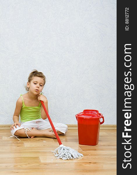 Little girl cleaning the floor in the room