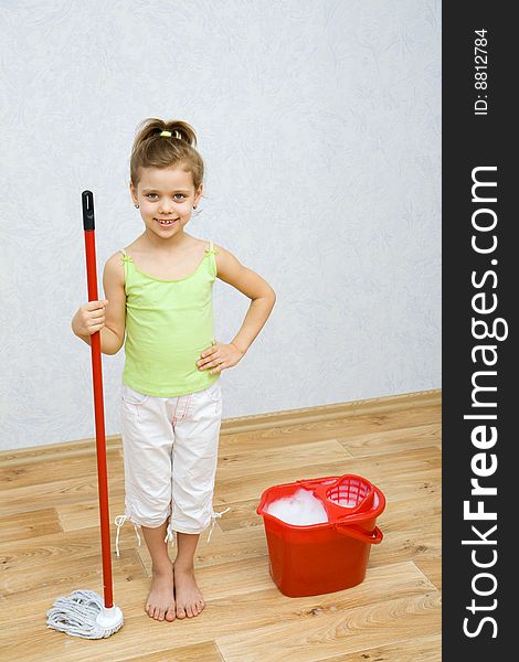 Little girl cleaning the floor in the room