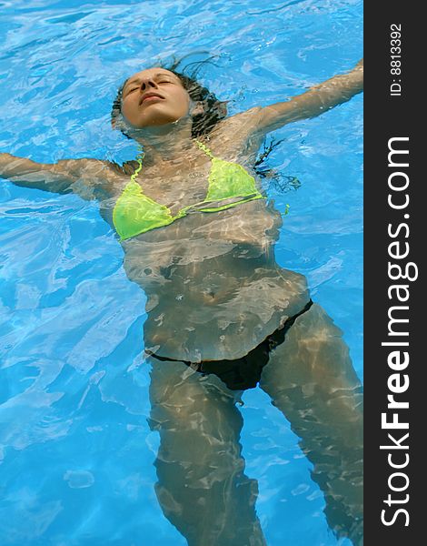 Woman takes a sunbath in the swimming pool. Woman takes a sunbath in the swimming pool