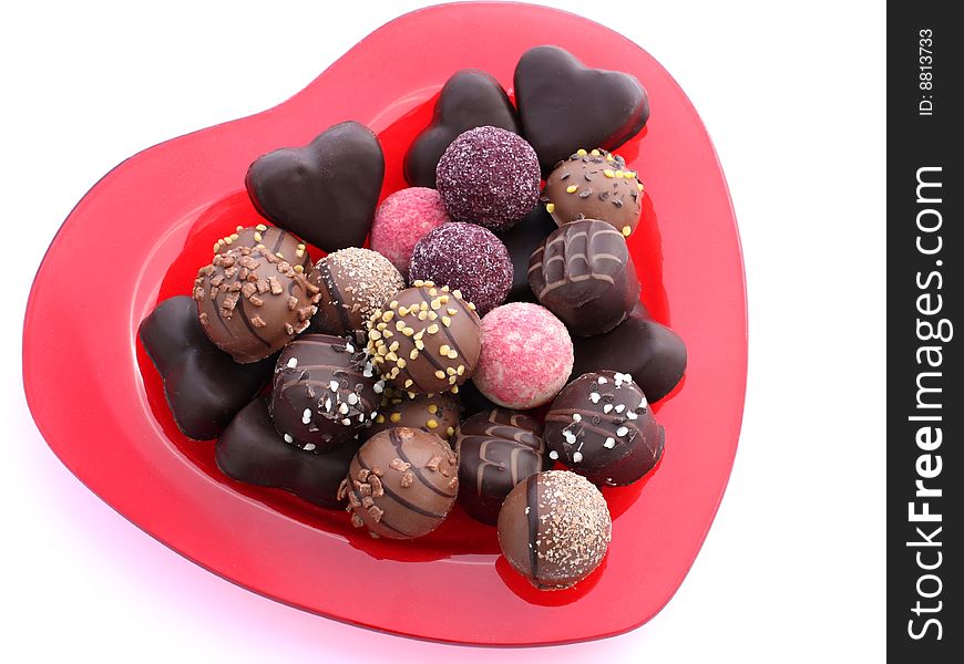 Different candies in a red glass bowl