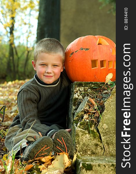 Sitting little boy with halloween pumpkin. Sitting little boy with halloween pumpkin